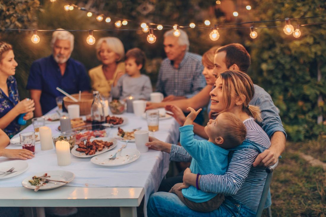 Family and friends enjoying an evening meal at an outdoor table - FloGas LPG for homes, BBQs and patio heaters from North East Bottled Gas